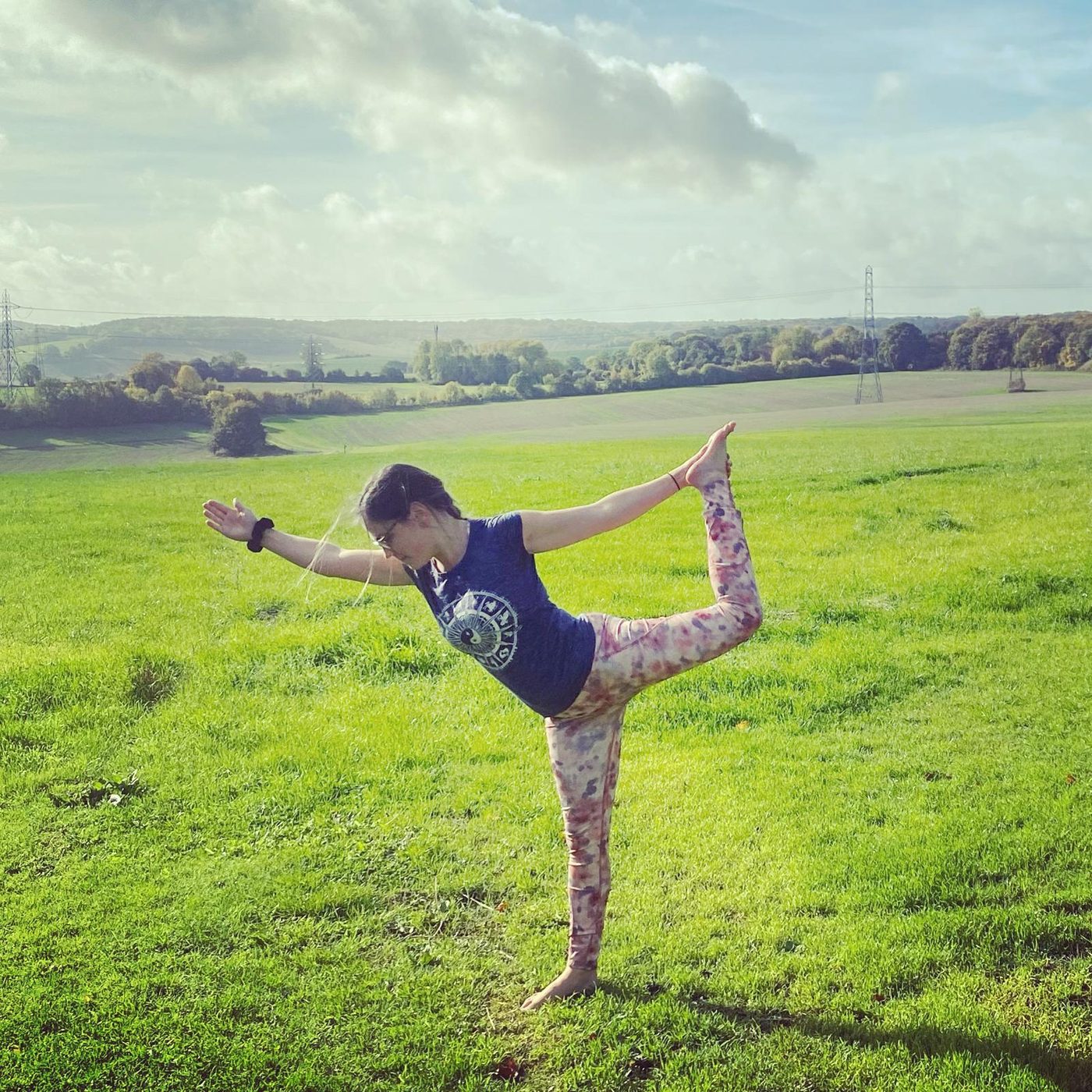 Jasmine in dancer's pose in a wide green field under a big Kent sky